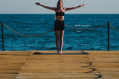 young woman doing yoga on the beach